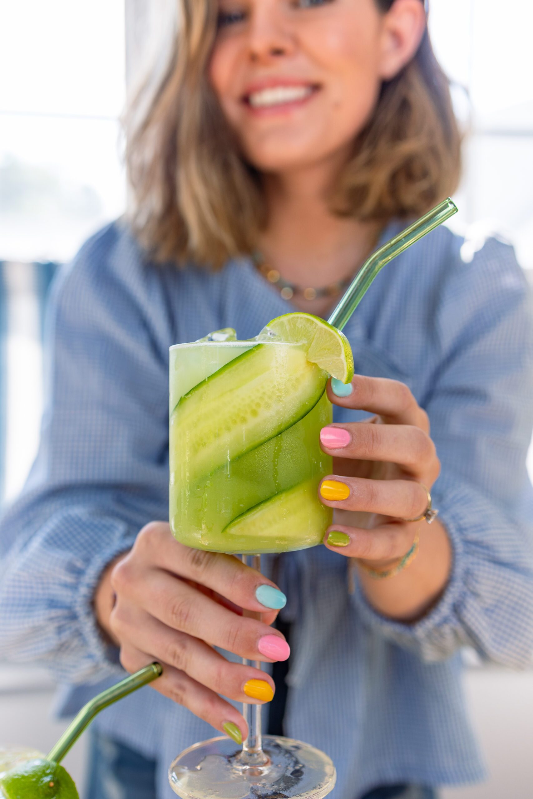 Clare Sullivan holding a summer Cucumber Lime Margarita